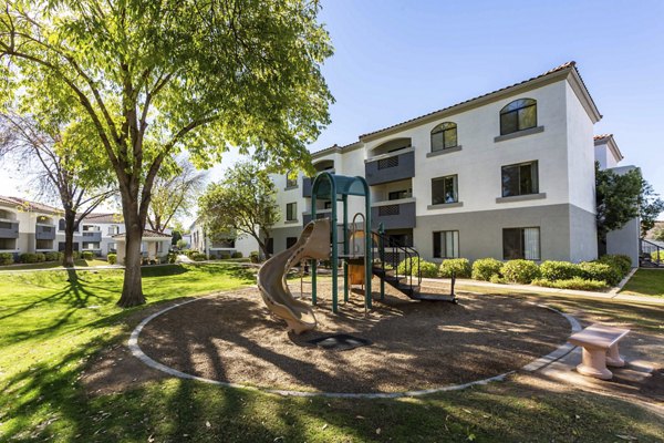 Children's playground with slides and swings at Avana Desert View Apartments
