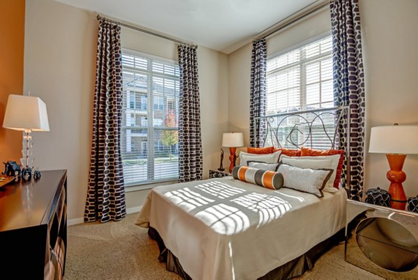 Spacious bedroom with modern decor at Whitehall Parc Apartment Homes, featuring large windows and neutral tones for a relaxing ambiance