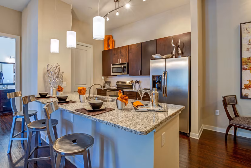 Modern kitchen featuring stainless steel appliances and granite countertops at Whitehall Parc Apartment Homes