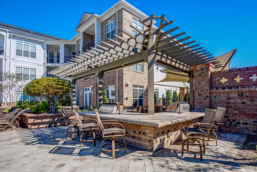 Outdoor grilling area with modern BBQ stations at Whitehall Parc Apartment Homes