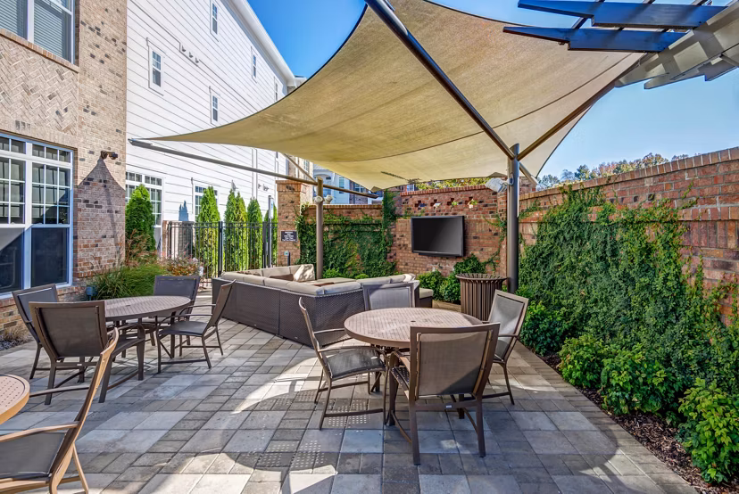 Outdoor grill area with modern seating at Whitehall Parc Apartment Homes, ideal for social gatherings and barbecues