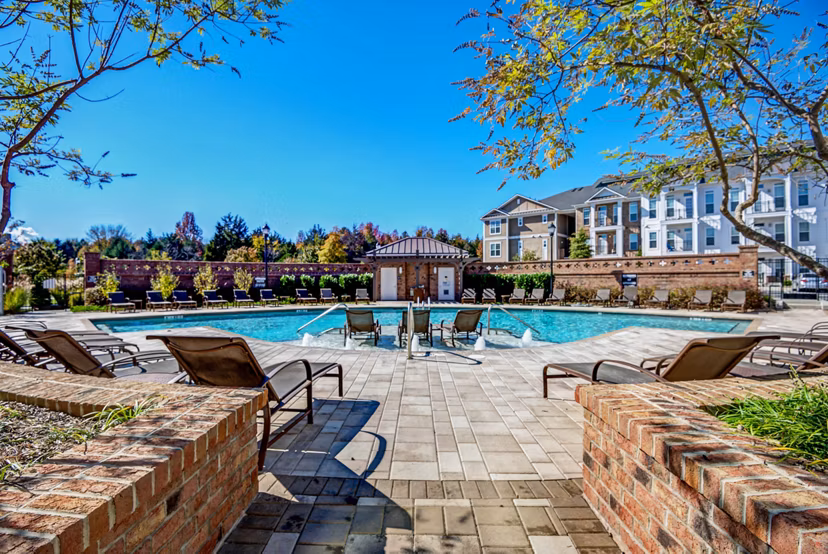 Pool with lounging chairs at Whitehall Parc Apartment Homes offering luxury relaxation