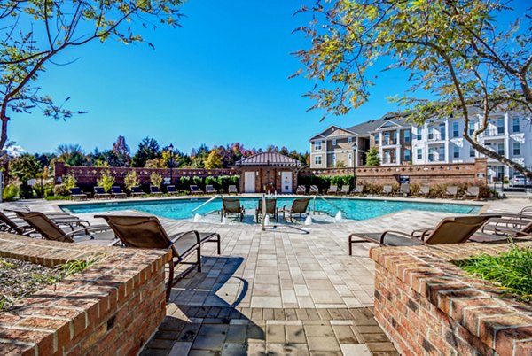 Pool with lounging chairs at Whitehall Parc Apartment Homes offering luxury relaxation
