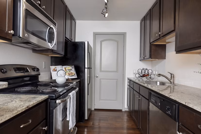 Modern kitchen with stainless steel appliances at Reserve at Garden Oaks apartments