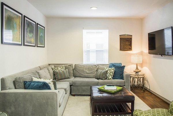 Spacious living room with modern decor and large windows in Reserve at Garden Oaks Apartments