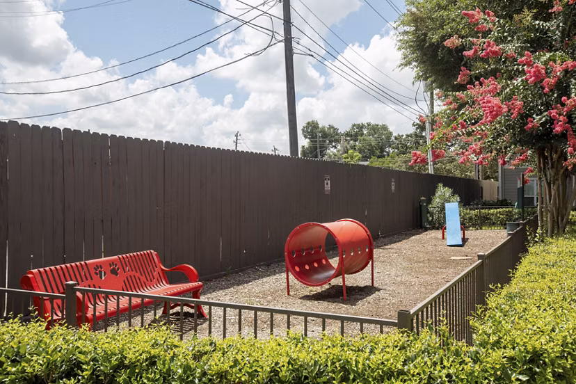 Outdoor grill area at Reserve at Garden Oaks Apartments with seating and lush greenery, perfect for gatherings in this luxury community