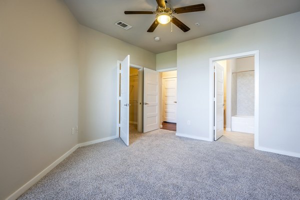 Spacious bedroom with modern decor at Tree Apartments, featuring elegant furnishings and ample natural light