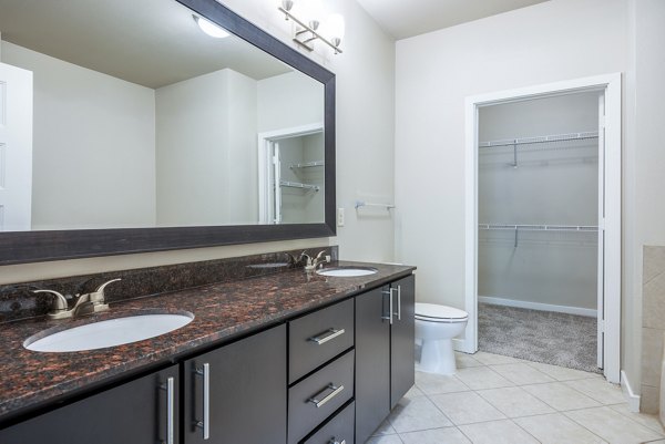 Bathroom featuring modern fixtures and white tiles in Tree Apartments