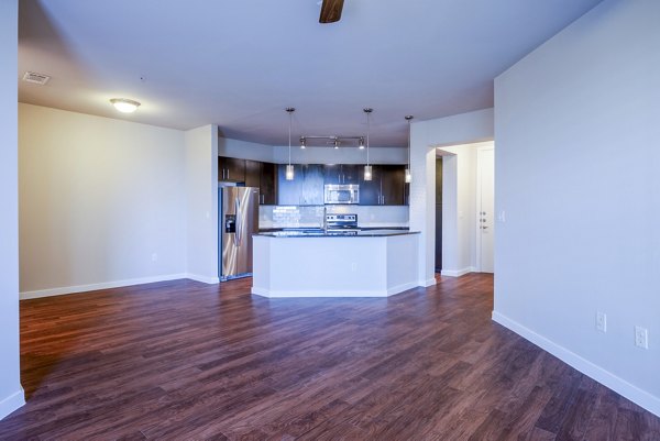 Modern living room featuring sleek furniture and large windows at Tree Apartments, luxury abode by Greystar