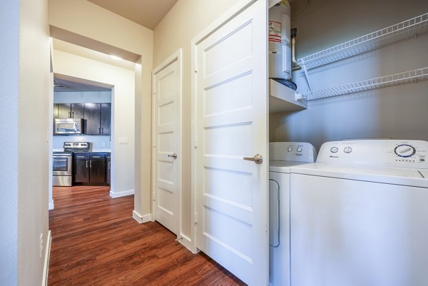 Modern laundry room with energy-efficient appliances at Tree Apartments
