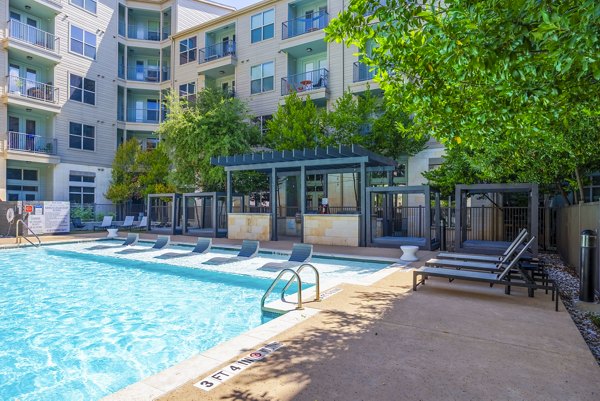Resort-style outdoor pool with lounge chairs at Tree Apartments