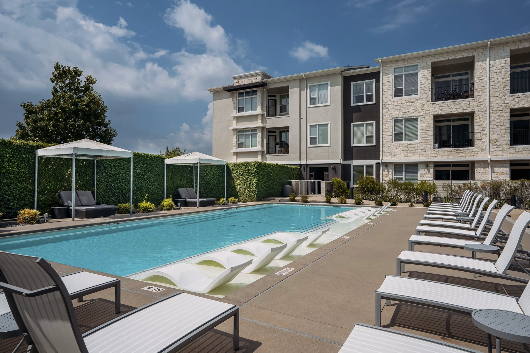 Luxurious poolside retreat at Lakeshore Pearl Apartments in Austin, TX with elegant seating and serene surroundings for ultimate relaxation