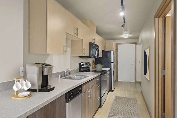 Modern kitchen with stainless steel appliances at 708 Uptown Apartments