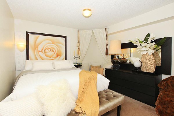 Modern bedroom with stylish decor at City View Apartments, featuring large windows and cozy bedding