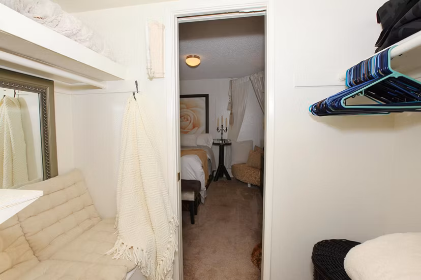 Walk-in closet with wooden shelves at City View Apartments