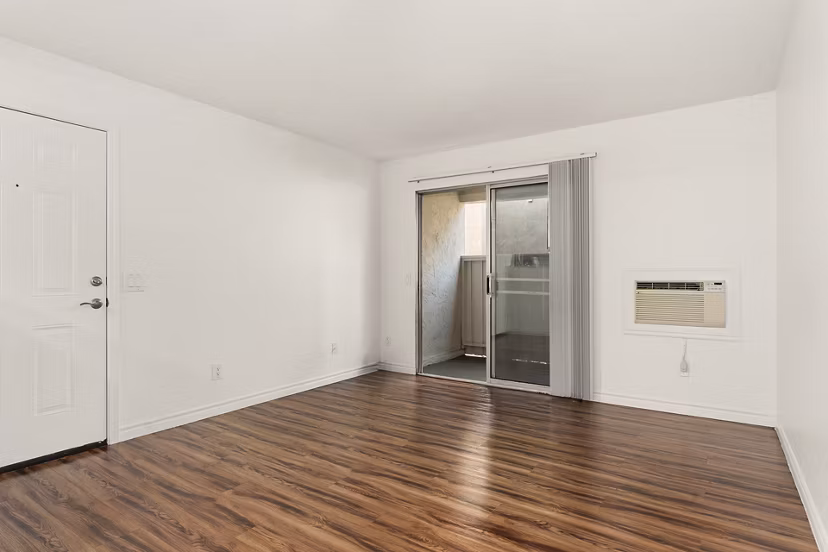 Contemporary living room with stylish decor and expansive windows at Whispering Oaks Apartments
