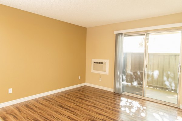 Contemporary living room with stylish decor and expansive windows at Whispering Oaks Apartments