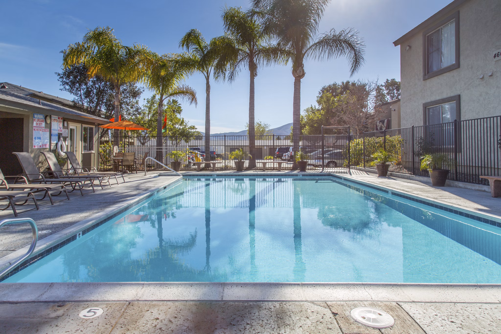 Pool area with lounge chairs and landscaped surroundings at Whispering Oaks Apartments, a luxury Greystar community