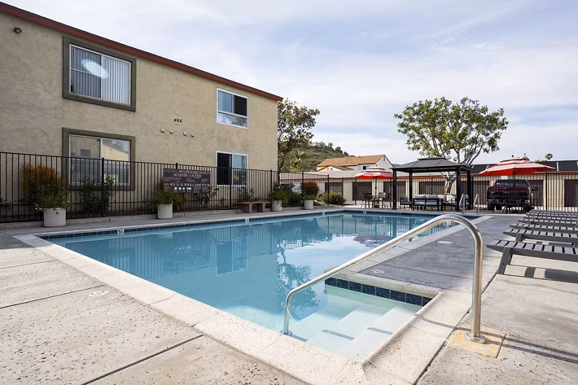Resort-style pool with sun loungers at Whispering Oaks Apartments