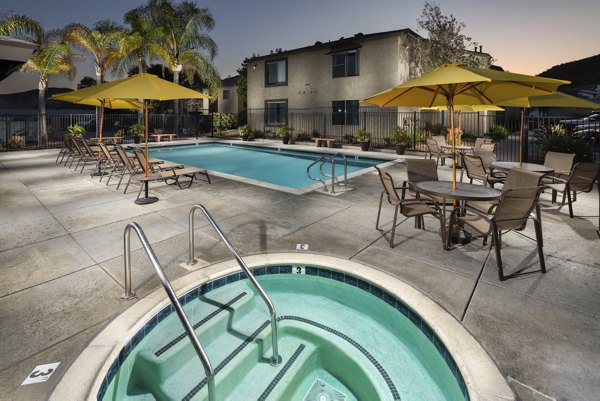Resort-style pool with sun loungers at Whispering Oaks Apartments