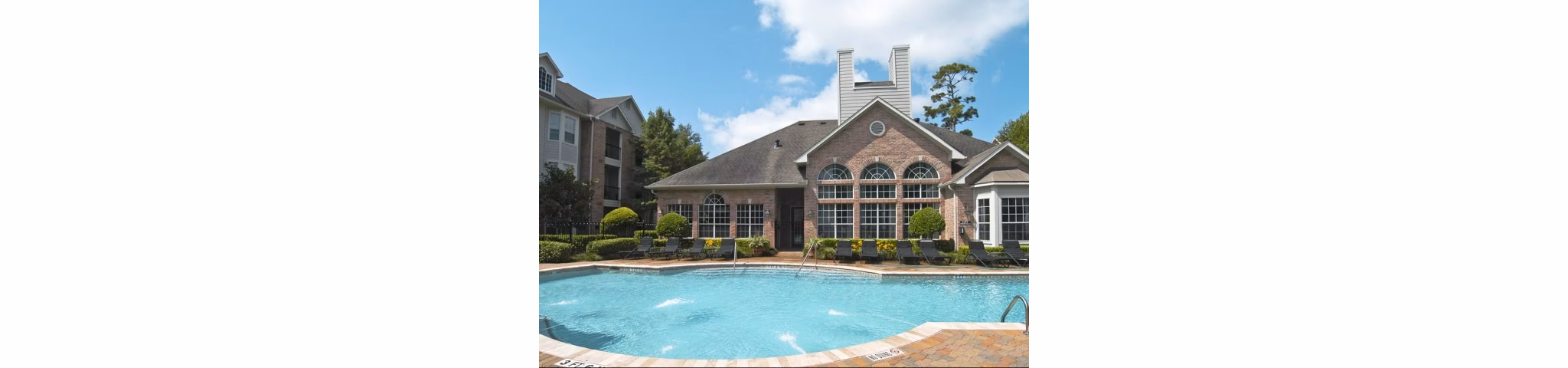 Swimming pool with lounge seating at Crossing at White Oak Apartments, offering a relaxing amenity for residents