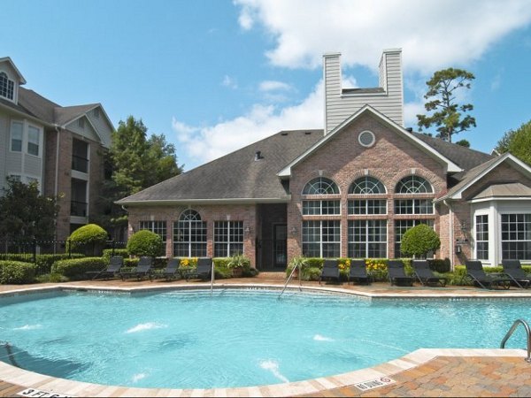 Swimming pool with lounge seating at Crossing at White Oak Apartments, offering a relaxing amenity for residents