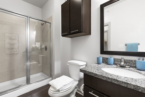 Modern bathroom with marble countertops and sleek fixtures in 95Twenty Apartments