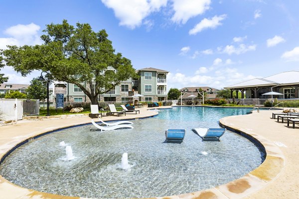 Luxurious poolside area at 95Twenty Apartments with relaxing loungers and surrounding greenery