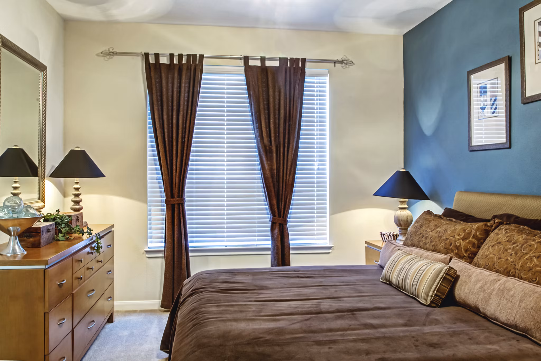 Cozy bedroom with modern furnishings at Plaza at Westchase Apartments