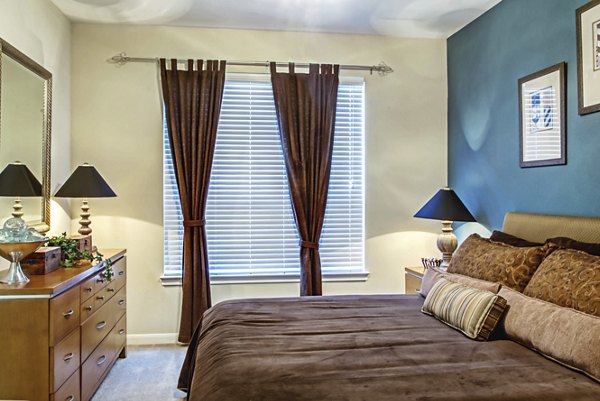 Cozy bedroom with modern furnishings at Plaza at Westchase Apartments