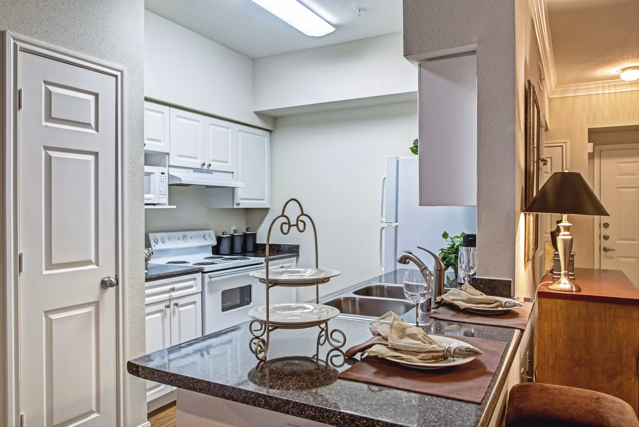 Modern kitchen with stainless steel appliances and granite countertops at Plaza at Westchase Apartments in a luxury Greystar community