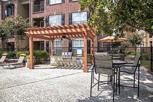 Patio with cozy seating area at Plaza at Westchase Apartments, offering a relaxing outdoor space for residents to enjoy
