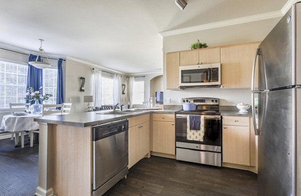 Modern kitchen with stainless steel appliances at Avana Thornton Station Apartments