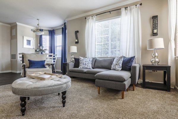 Modern living room with plush seating and large windows at Avana Thornton Station Apartments