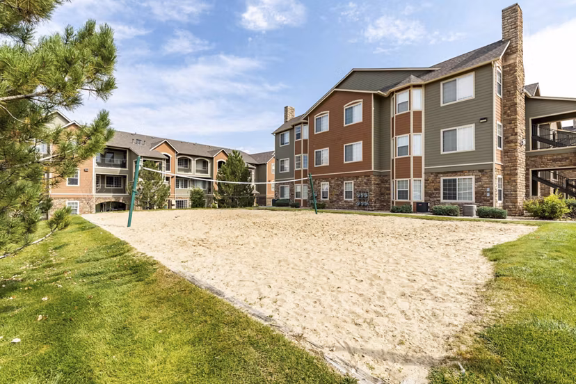 Outdoor patio with seating area at Avana Thornton Station Apartments featuring lush landscaping