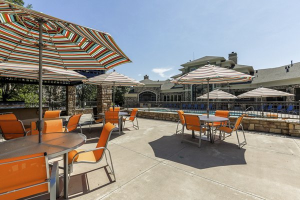 Outdoor patio with seating area at Avana Thornton Station Apartments featuring lush landscaping