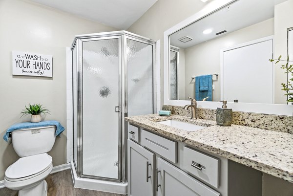 Modern bathroom featuring elegant fixtures and large vanity at Ellipse at Fairfax Corner Apartments