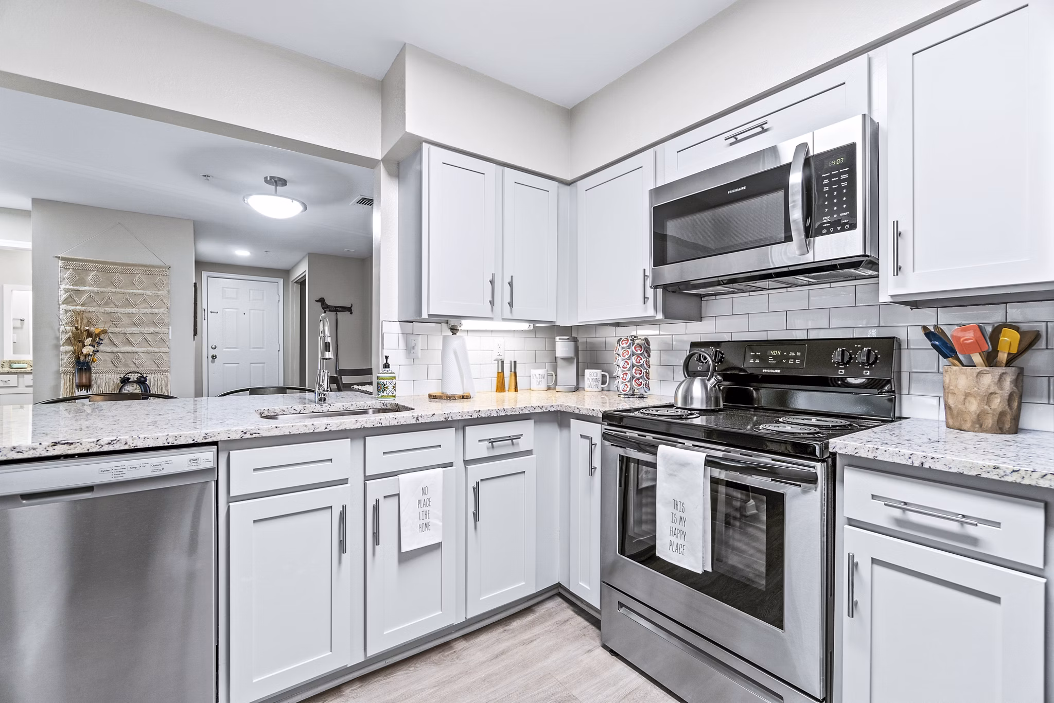 Ellipse at Fairfax Corner: Modern kitchen with stainless steel appliances and granite countertops in luxury apartment