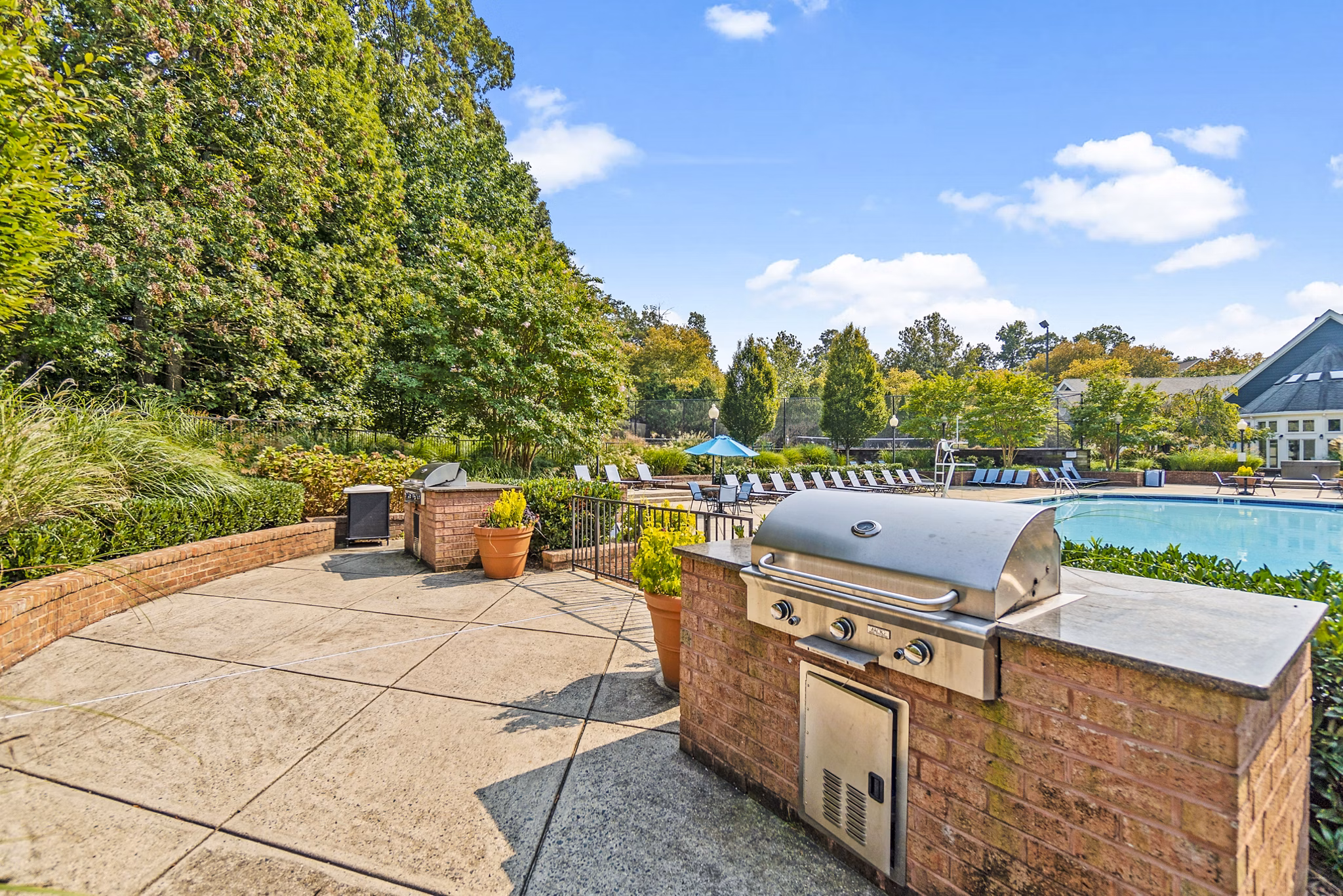 Outdoor grill area by the pool at Ellipse at Fairfax Corner Apartments
