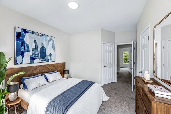 Contemporary bedroom featuring plush bedding and modern decor at Townes at Herndon Apartments