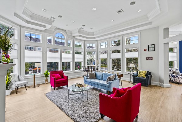 Clubhouse at Townes at Herndon Apartments featuring modern design and seating areas