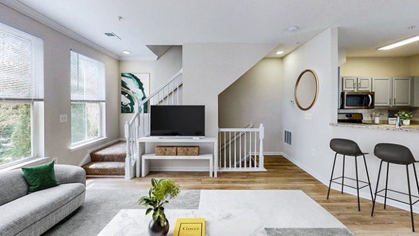 Living room with cozy seating and large windows at Townes at Herndon Apartments