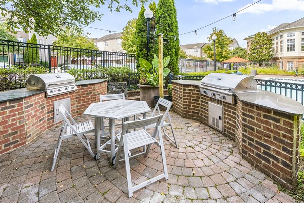 Outdoor grill area and patio at Townes at Herndon Apartments offering communal cooking and seating spaces in a luxury setting