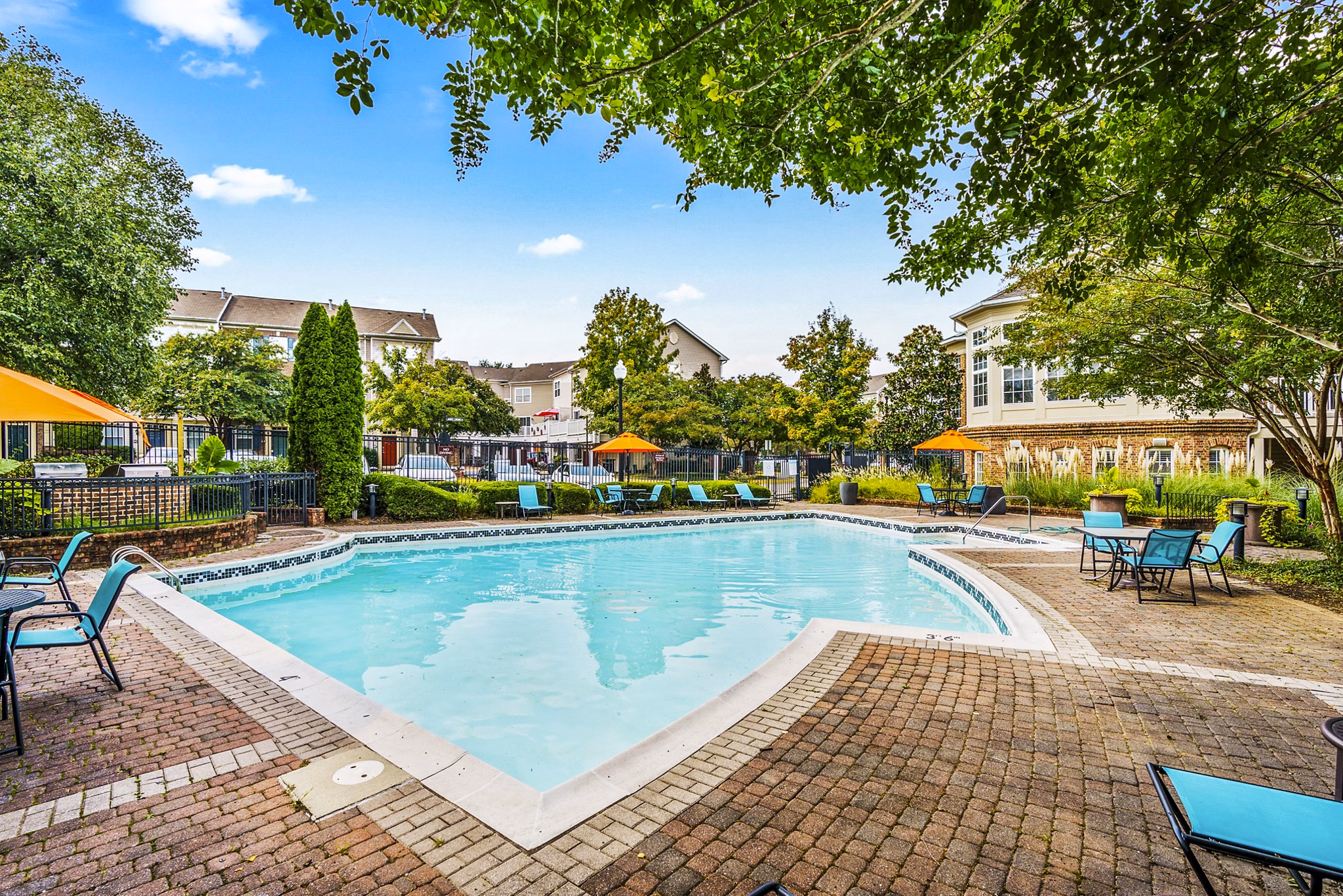 Outdoor pool with lounge seating at Townes at Herndon Apartments, a Greystar luxury apartment community