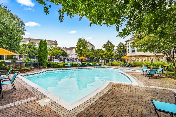 Outdoor pool with lounge seating at Townes at Herndon Apartments, a Greystar luxury apartment community