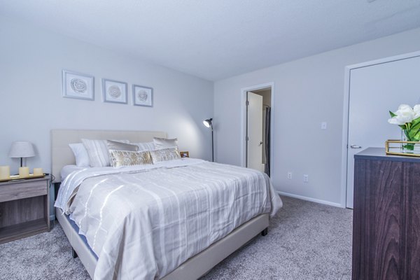 Cozy bedroom featuring stylish decor and ample natural light at Windsor at Fairlakes Apartments
