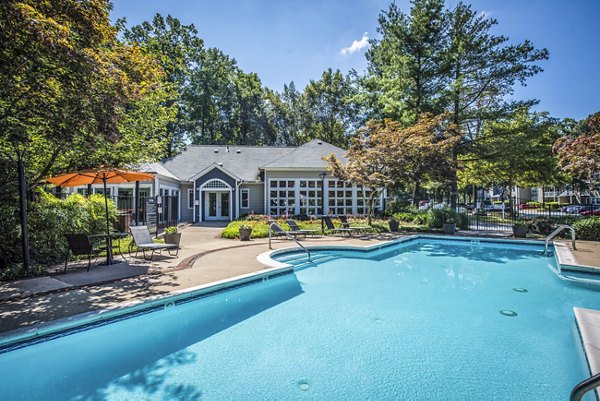 Community pool with lounge chairs at Windsor at Fairlakes Apartments, offering residents a relaxing oasis in a beautiful setting