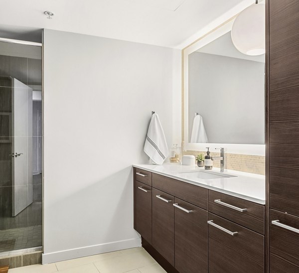 Bathroom featuring modern fixtures and elegant tiling at The Goodwin Apartments
