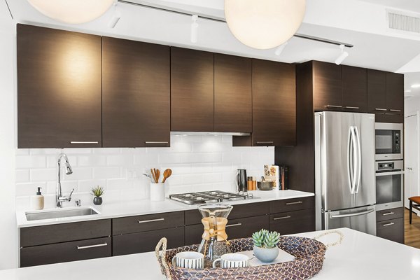 Modern kitchen with stainless steel appliances and sleek countertops at The Goodwin Apartments