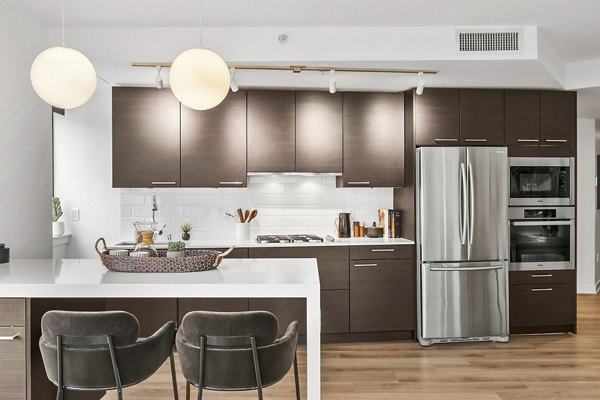 Kitchen featuring modern appliances and granite countertops in The Goodwin Apartments, a luxury residence designed by Greystar